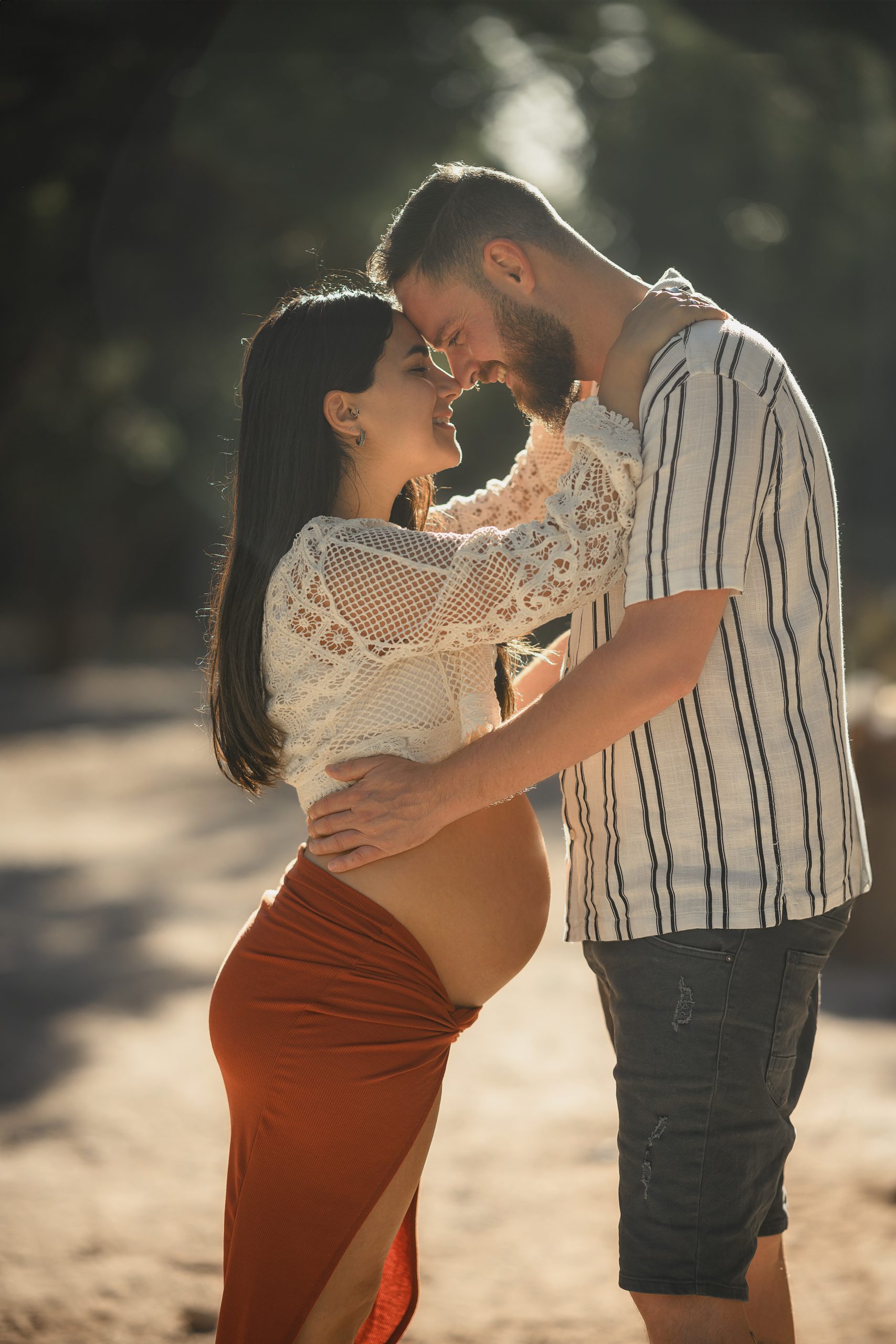 צילומי הריון בטבע 5 צילומי הריון זוגיים בשביל עצים — בני זוג מצח אל מצח באור שקיעה